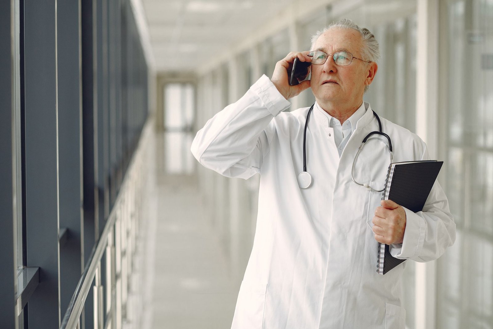Veteran aviation mechanic discussing asbestos exposure health screening with a clinician in a bright modern clinic