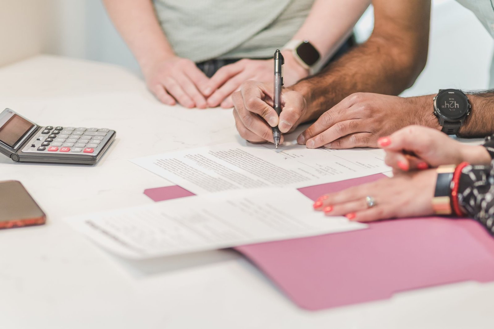 Hands completing forms and using a calculator to check loan forgiveness for a disabled veteran