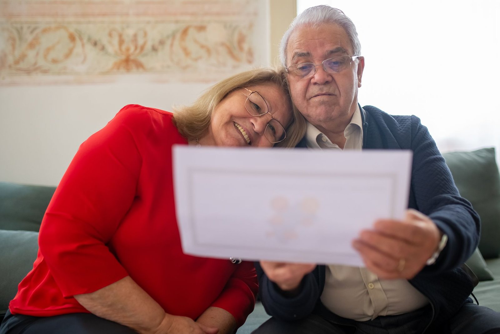 Senior veteran and spouse reviewing paperwork for an Agent Orange herbicide exposure VA claim at home